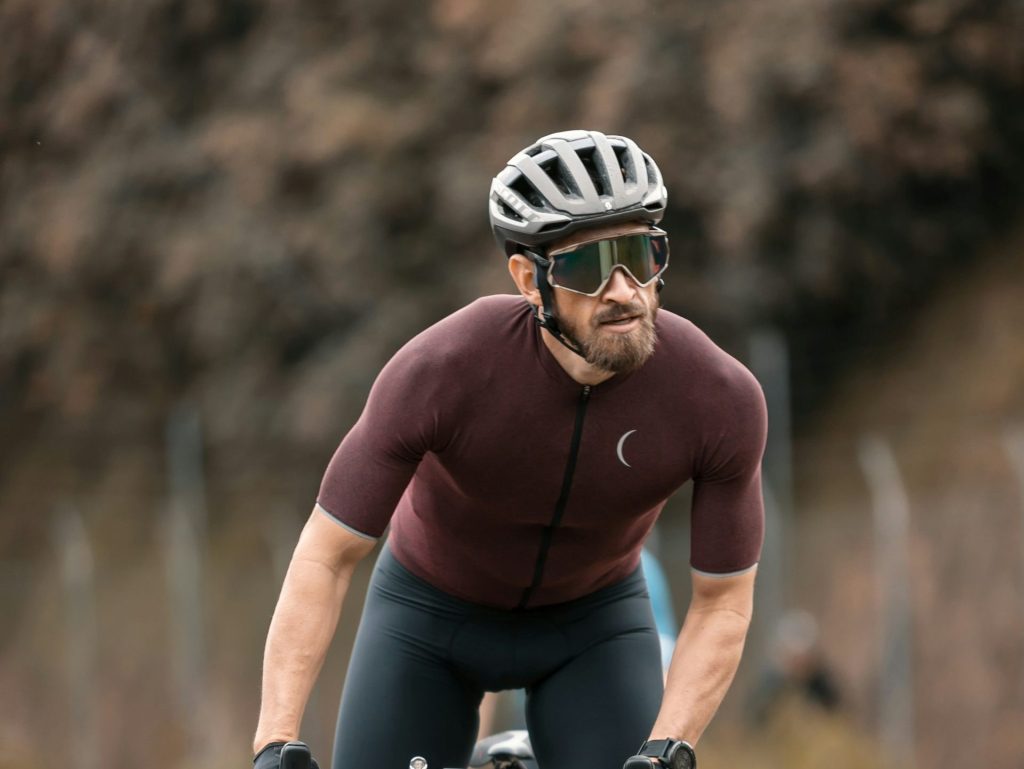 Homme en chemise rouge à manches longues sur un vélo noir