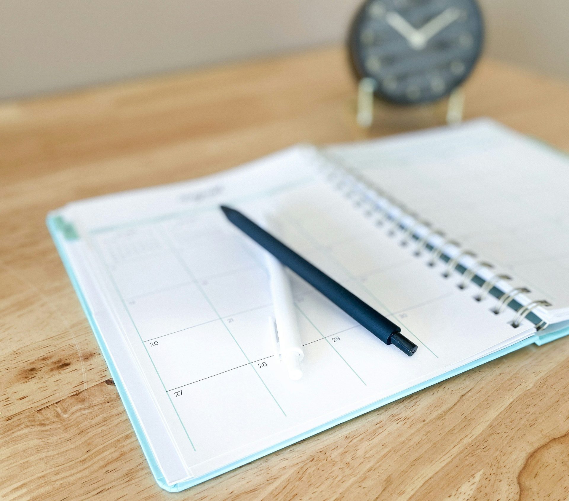Un agenda ouvert avec un stylo sur un bureau en bois.
